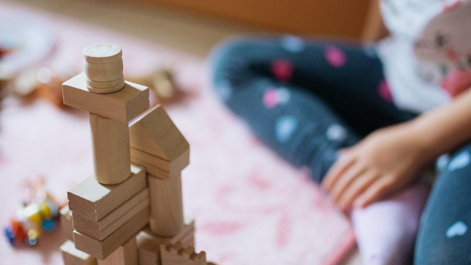 Jouets Montessori en bois posés sur un tapis beige