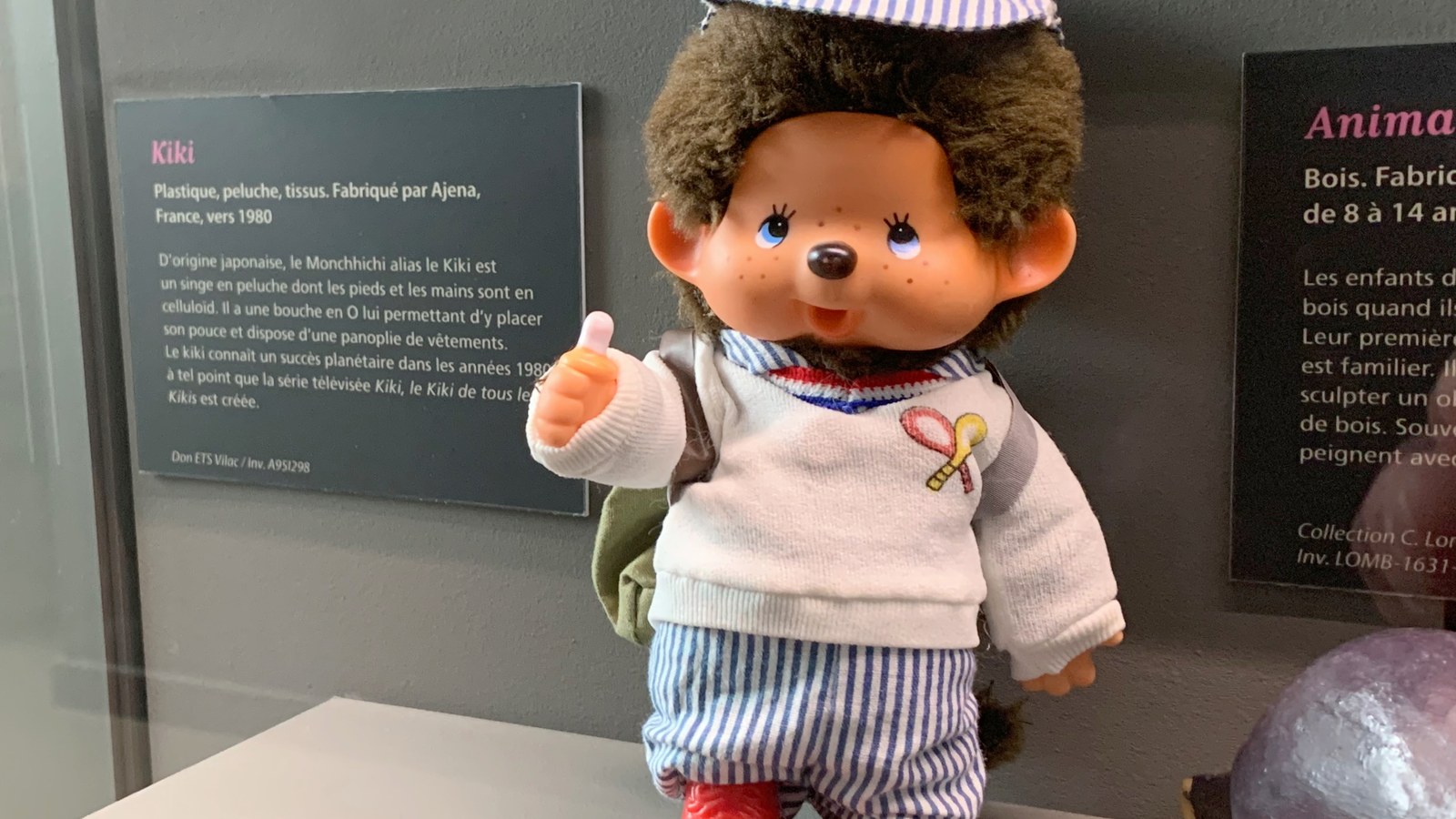 Poupée en chiffon et jouet en bois disposés sur un tapis en laine beige