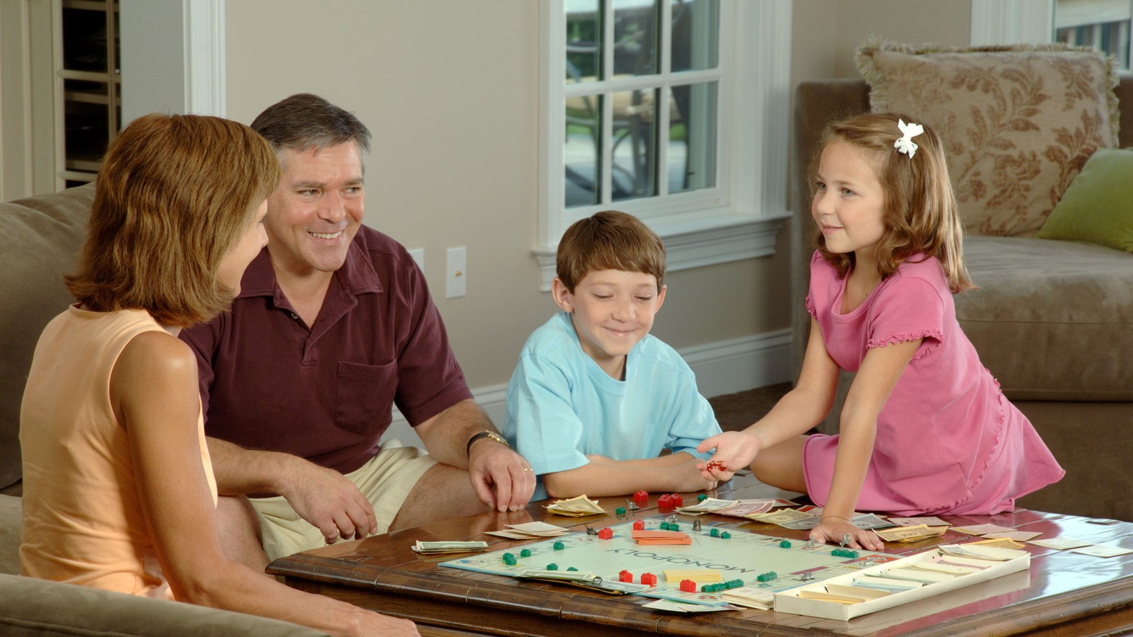 Famille jouant à un jeu de société coopératif autour de la table