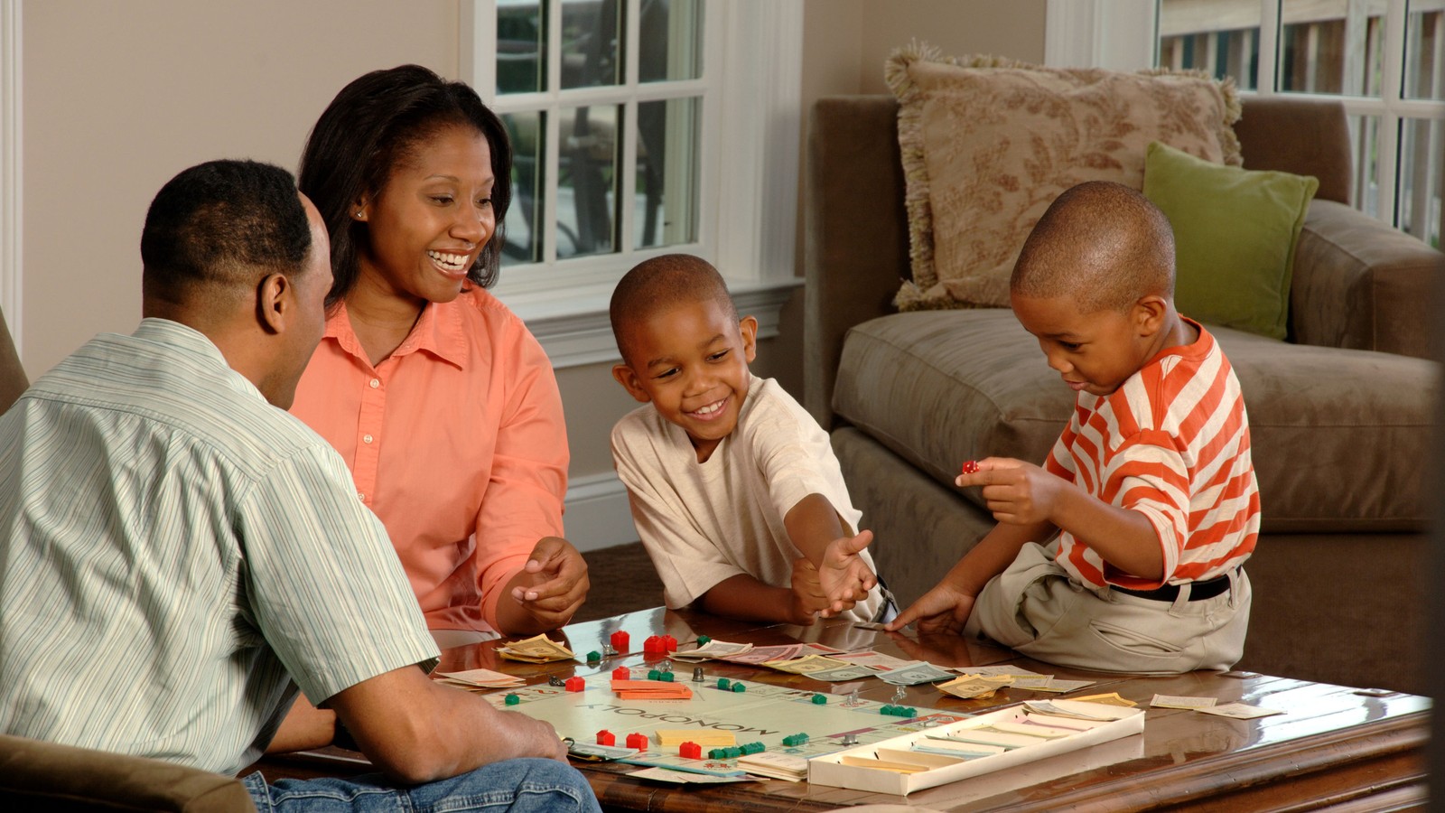 Enfants et parents jouant à un jeu de société coopératif en famille