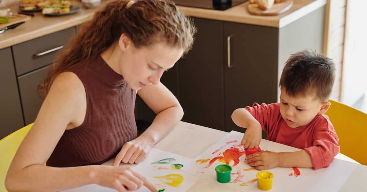 Maman et bébé faisant de la peinture aux doigts ensemble à la cuisine