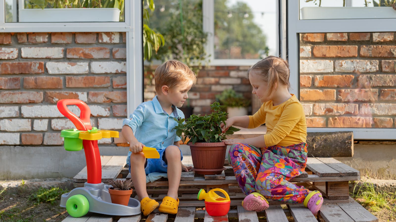 Enfants assis dehors avec un kit de jardinage pour enfants