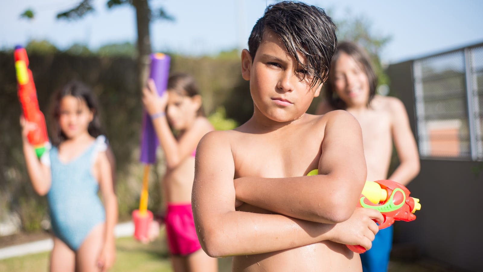 Enfants qui jouent avec des pistolets à eau dans le jardin