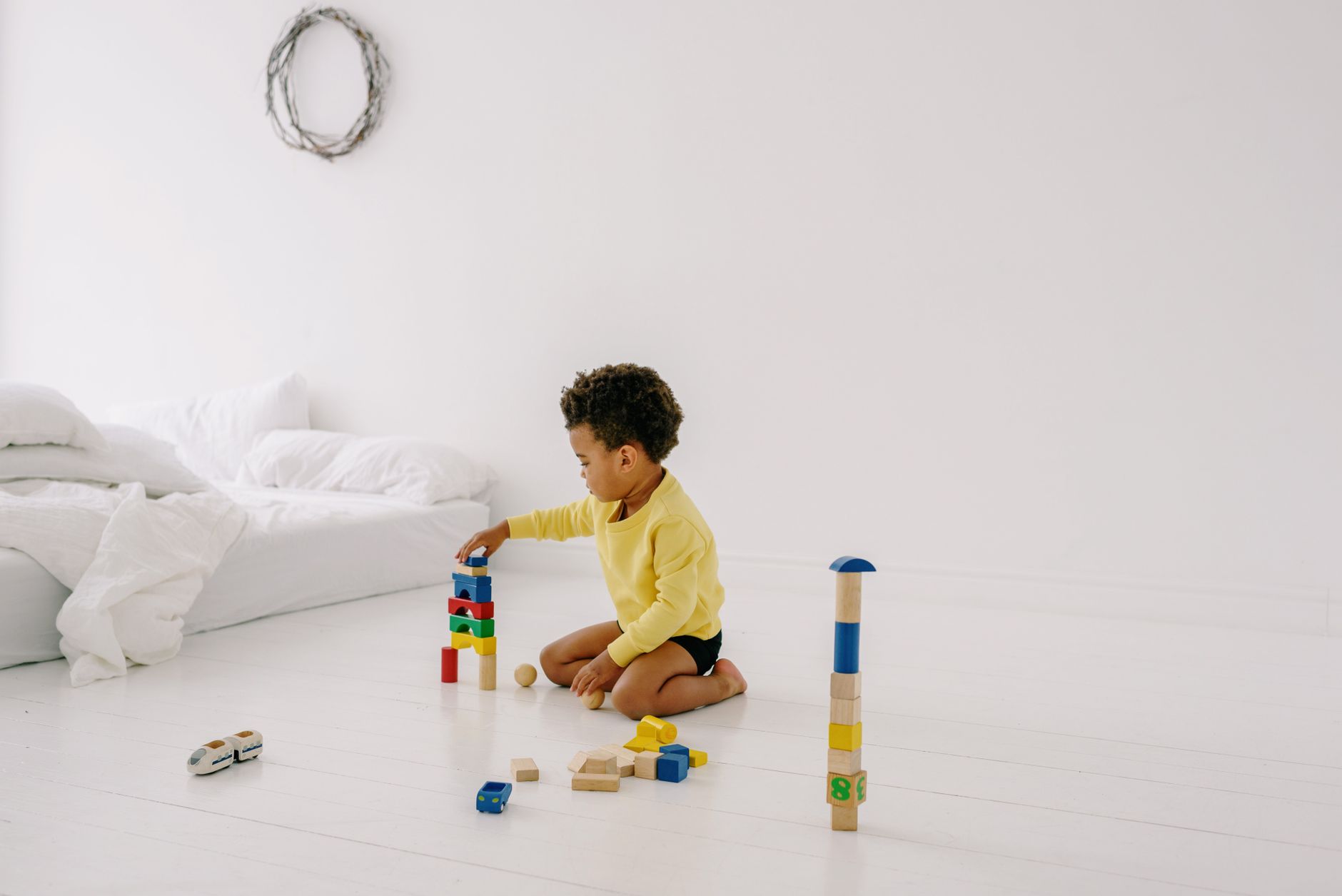 enfant jouant avec des jouets de construction en bois colorés