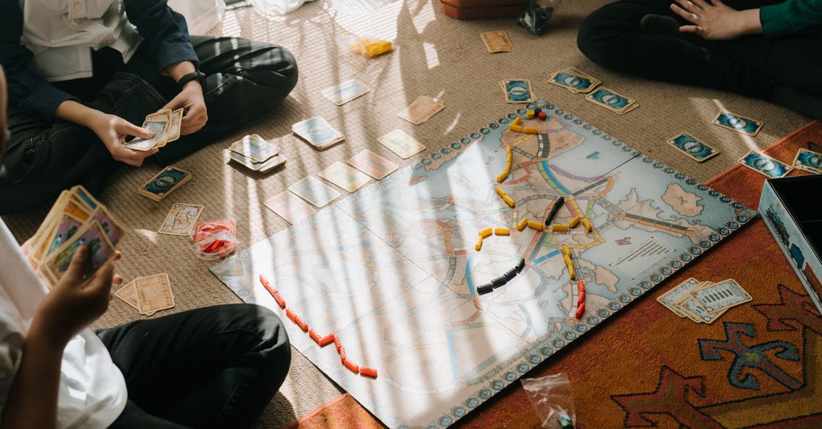 Enfants concentrés sur un jeu de plateau en famille