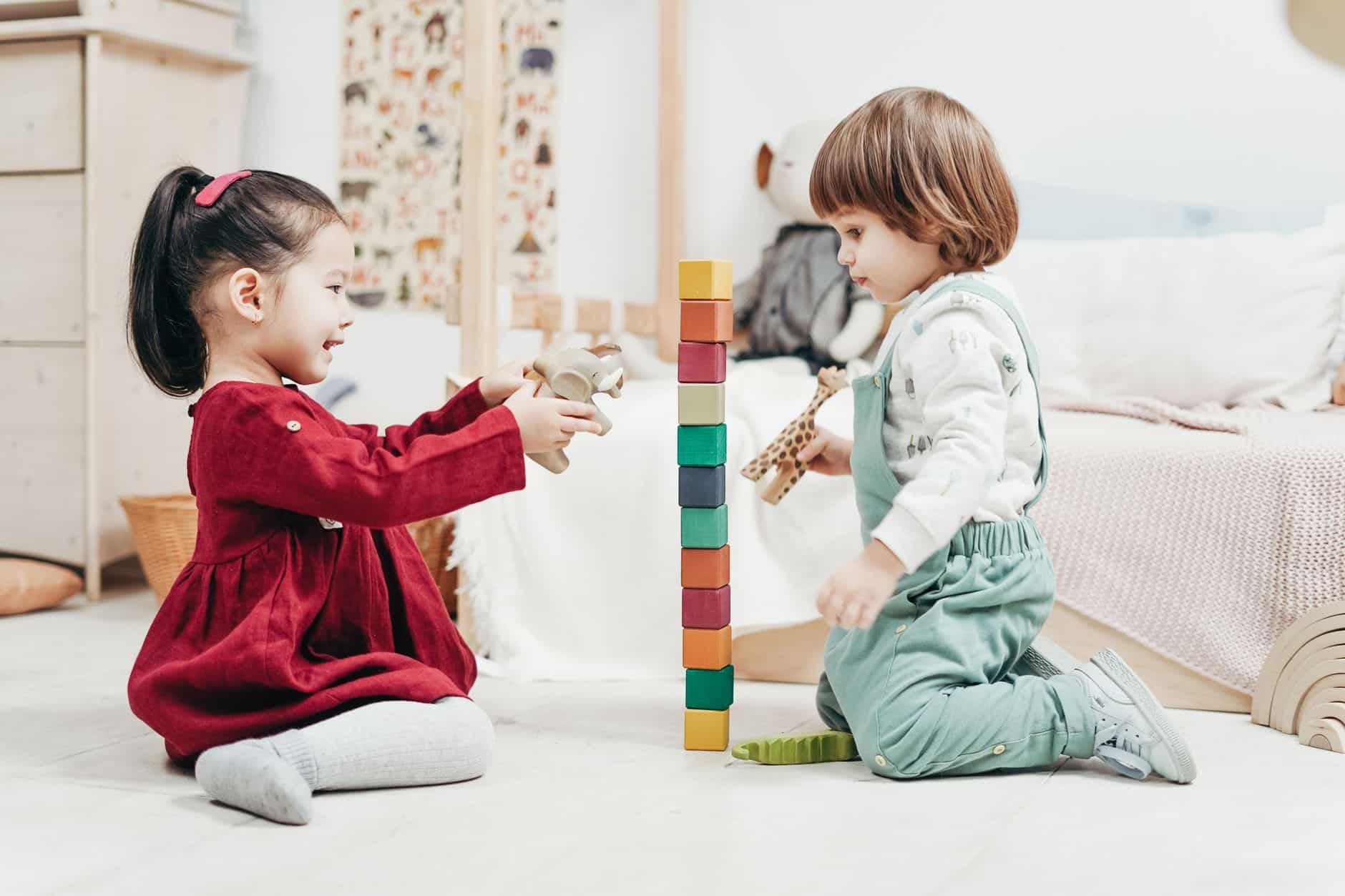 deux enfants construisant une tour de cubes en bois